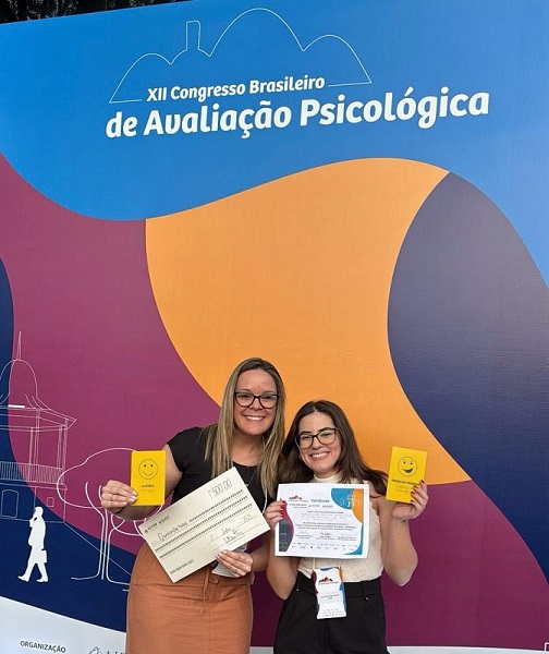 Professora Carolina e a discente Luisa na premiação mostram o Emotátil